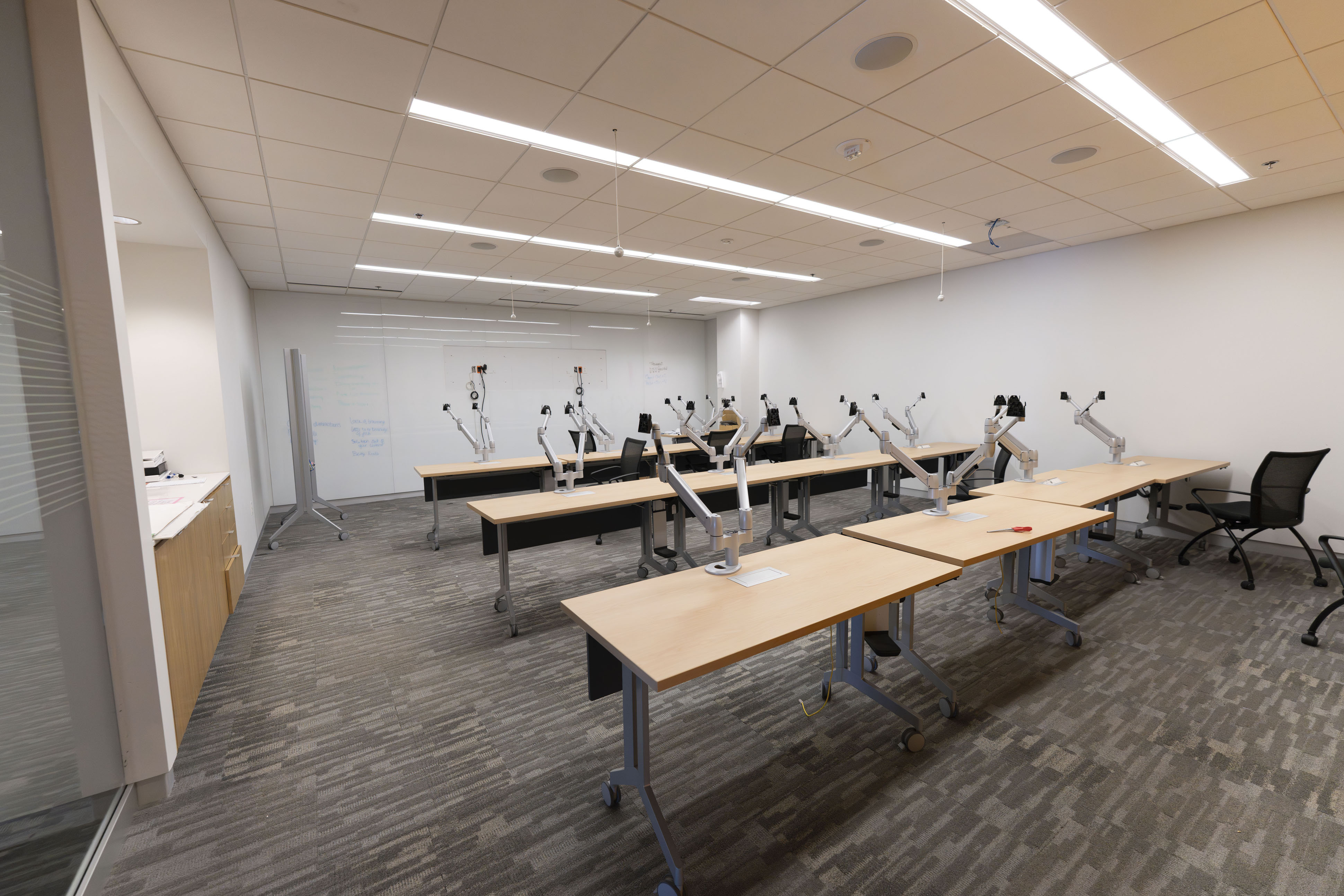 Centennial Building computer training room with 12 fixed workstations, monitor arms, and instructor station
